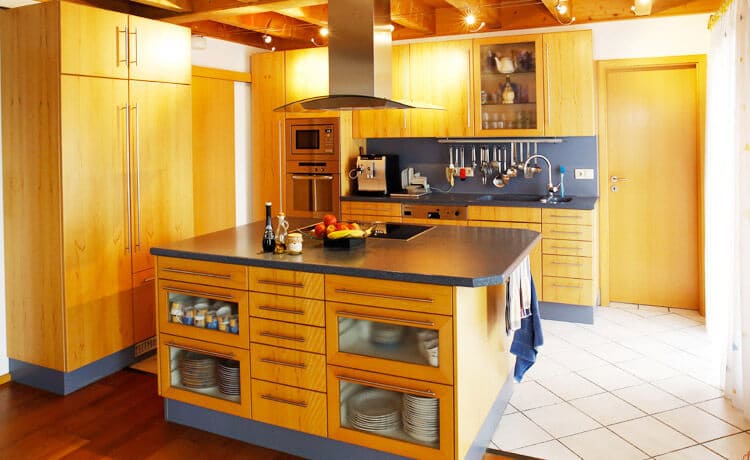 Küche mit Kochinsel in Blau kombiniert mit Kernbuche