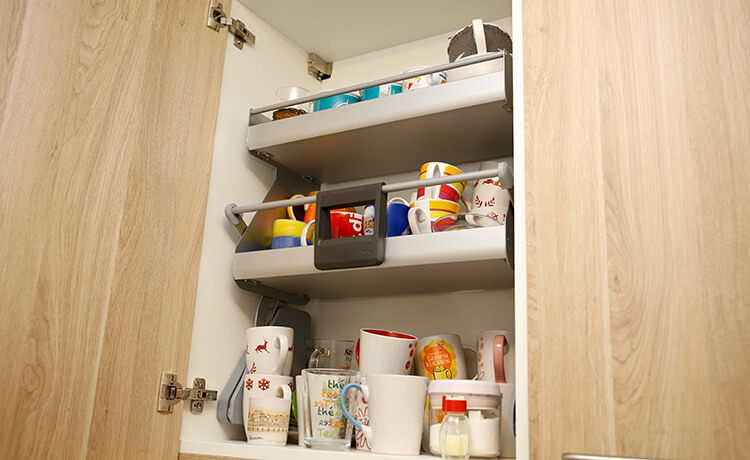 Single-Küche mit ausklappbaren Fachböden im Oberschrank von Schreinerei Binder